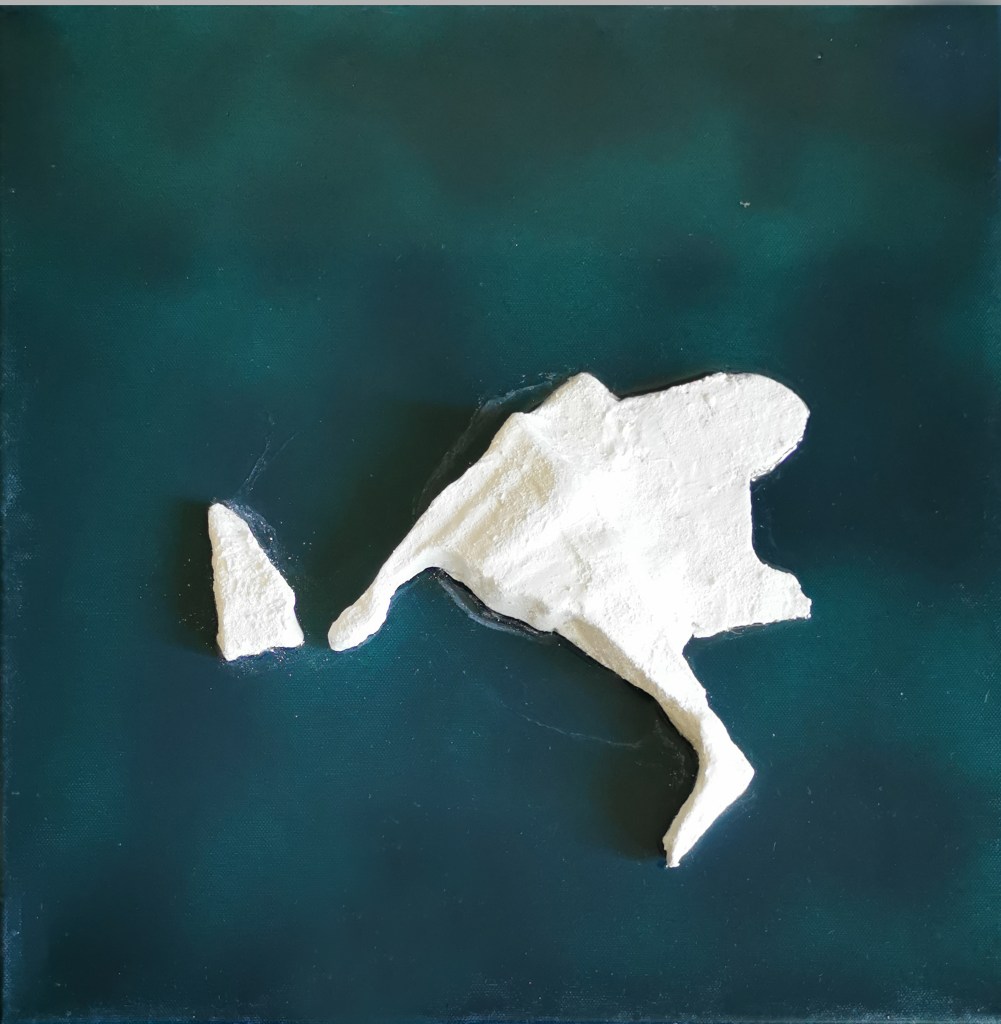 Contemporary artwork named as solitudes. square framed artwork with blue-green background. varnished with resin. In the middle is a hand shaped three dimensional iceberg colored in white with acrylic and pigments.