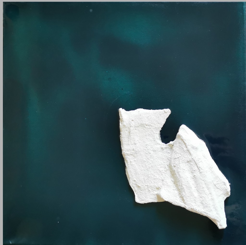 Contemporary artwork named as solitudes. square framed artwork with blue-green background. varnished with resin. In the middle is a hand shaped three dimensional iceberg colored in white with acrylic and pigments.