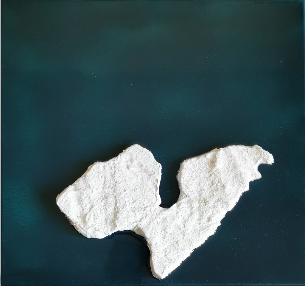 Contemporary artwork named as solitudes. square framed artwork with blue-green background. varnished with resin. In the middle is a hand shaped three dimensional iceberg colored in white with acrylic and pigments.